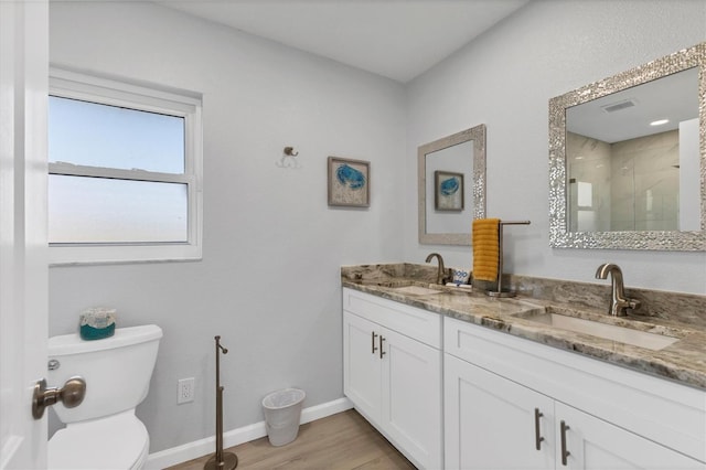 bathroom with vanity, toilet, wood-type flooring, and walk in shower