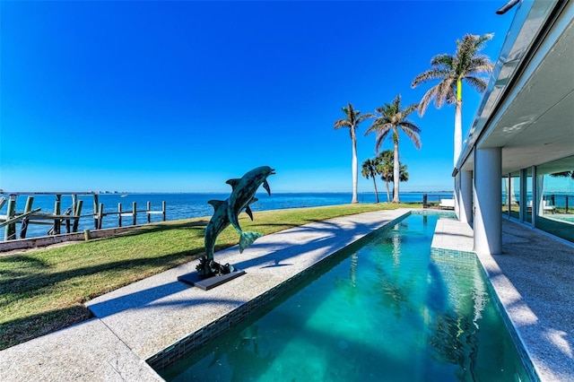 view of pool with a lawn, a dock, and a water view