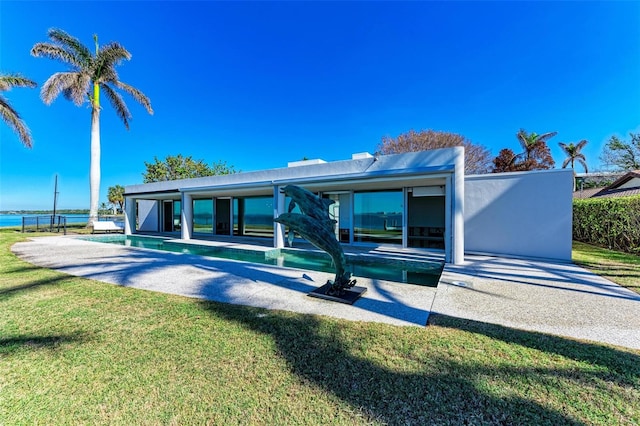 back of house featuring a lawn and a water view