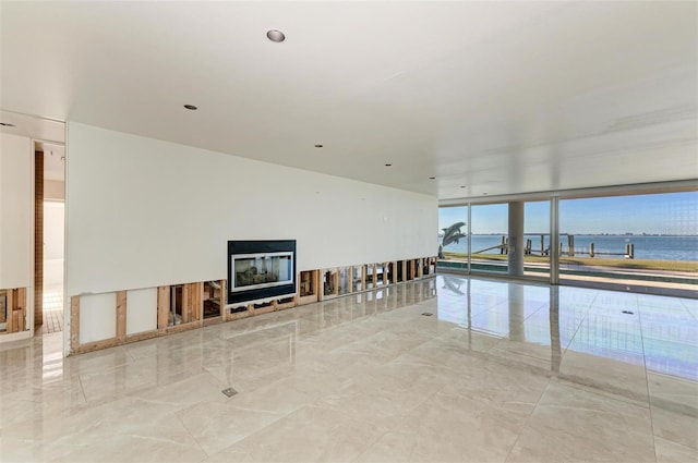 unfurnished living room with a water view and a wall of windows