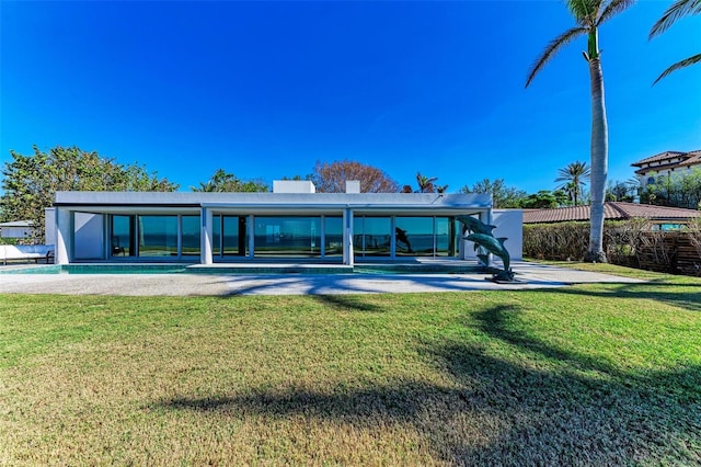 rear view of house featuring a lawn