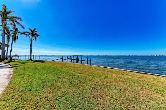 view of dock featuring a water view and a yard