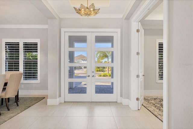 entrance foyer featuring crown molding, french doors, light tile patterned flooring, and an inviting chandelier