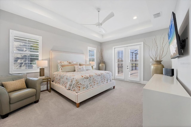 carpeted bedroom with french doors, access to outside, ceiling fan, and a tray ceiling