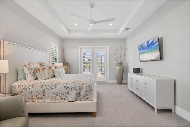 carpeted bedroom featuring access to outside, ceiling fan, and a tray ceiling