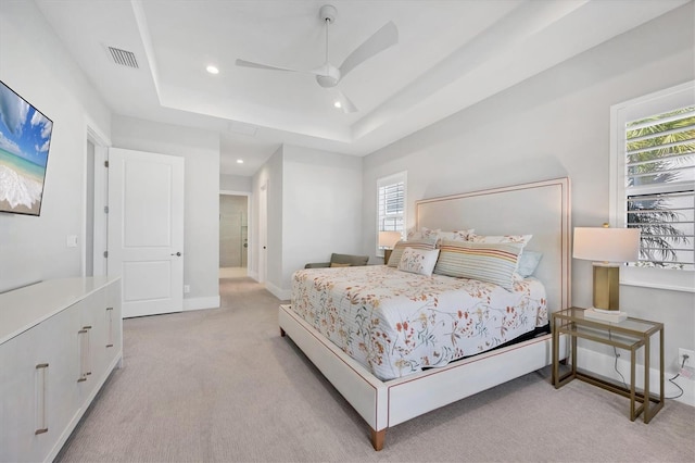 bedroom with a tray ceiling, ceiling fan, and light colored carpet