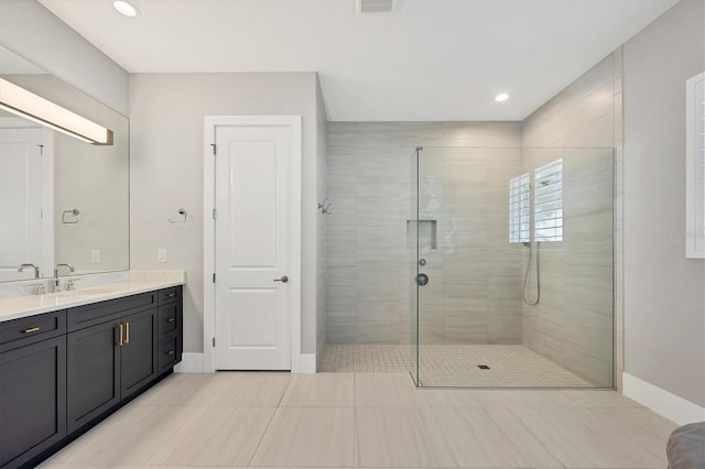 bathroom with tile patterned floors, vanity, and a tile shower