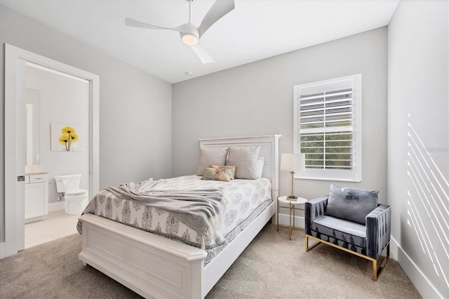 bedroom with ensuite bath, ceiling fan, and light colored carpet