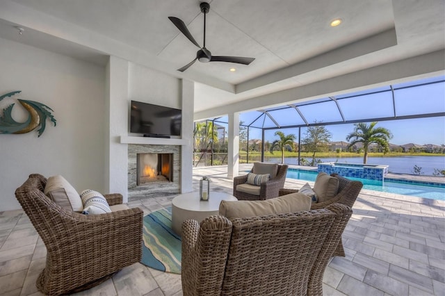 view of patio featuring glass enclosure, ceiling fan, and an outdoor fireplace