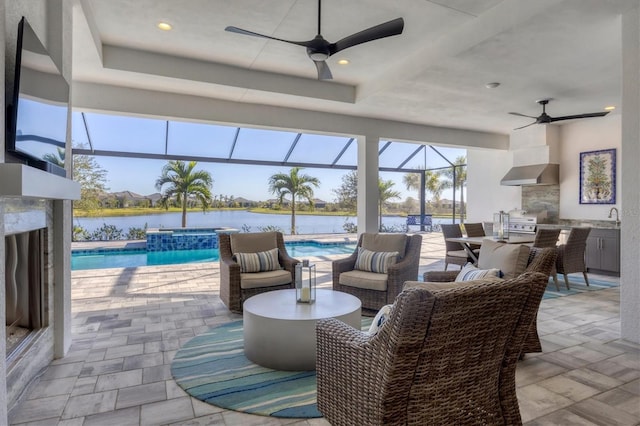 view of patio / terrace with an outdoor kitchen, a pool with hot tub, a lanai, and sink