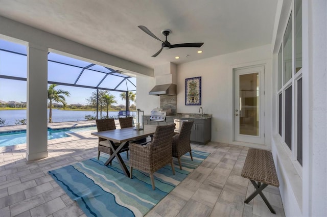 view of patio / terrace with an outdoor kitchen, a water view, sink, a lanai, and a grill