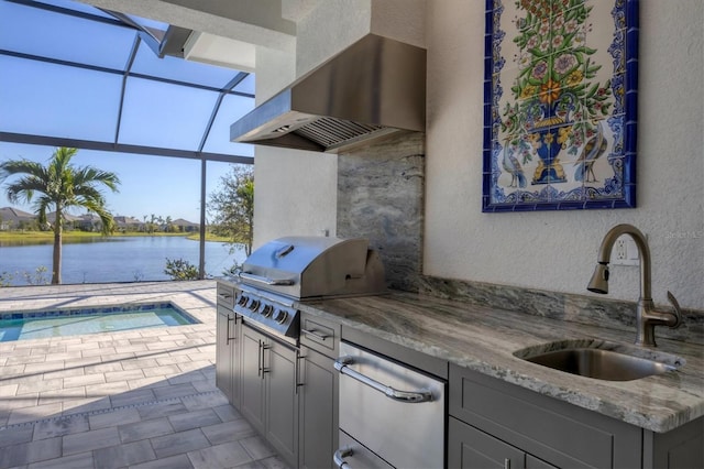 view of patio featuring an outdoor kitchen, sink, a water view, glass enclosure, and a grill