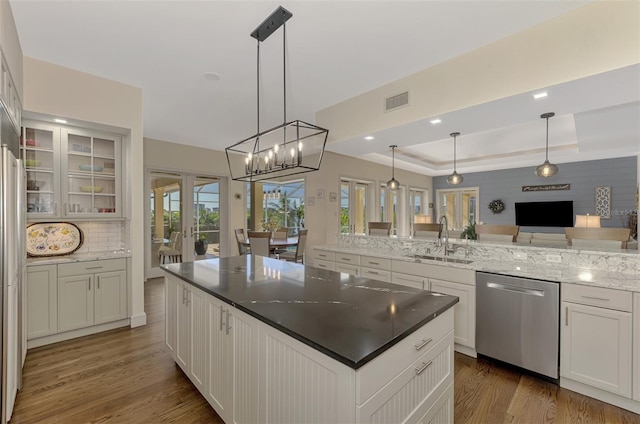 kitchen featuring dishwasher, pendant lighting, a tray ceiling, and sink