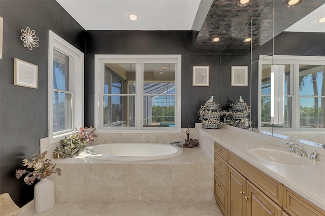 bathroom with tile patterned floors, tiled bath, and vanity