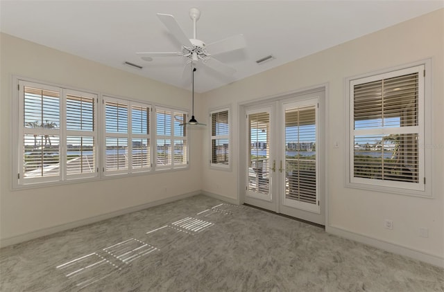 spare room featuring ceiling fan, light carpet, and french doors