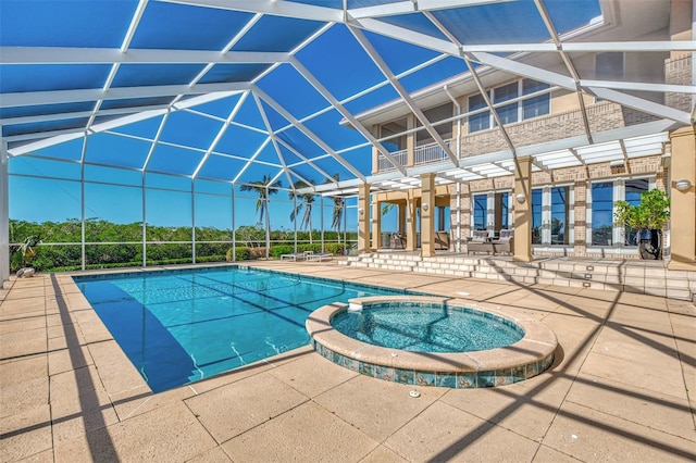 view of swimming pool featuring a lanai, a patio area, and an in ground hot tub