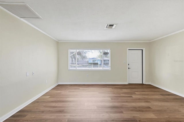 spare room featuring wood-type flooring and ornamental molding