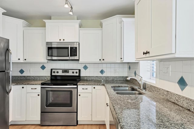 kitchen featuring white cabinets, sink, appliances with stainless steel finishes, and tasteful backsplash