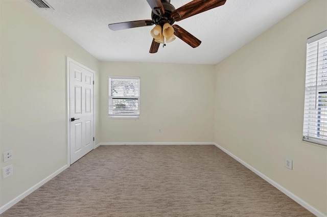 empty room with light carpet, ceiling fan, and a textured ceiling