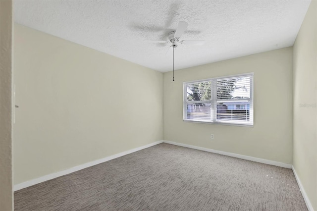 empty room with carpet flooring, ceiling fan, and a textured ceiling