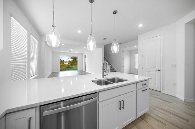 kitchen featuring stainless steel dishwasher, pendant lighting, white cabinets, and sink