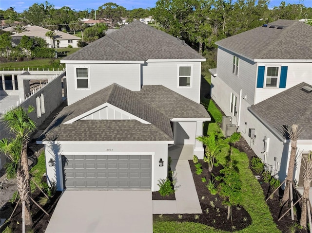 view of front of home with a garage, concrete driveway, and roof with shingles