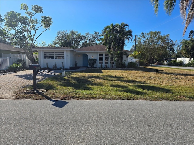 ranch-style home featuring a front lawn