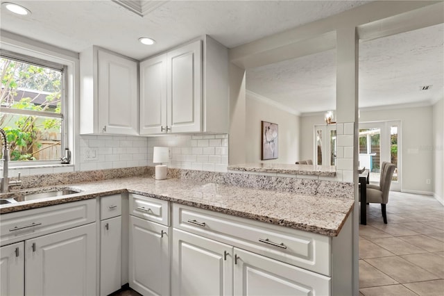 kitchen with white cabinets, backsplash, plenty of natural light, and sink