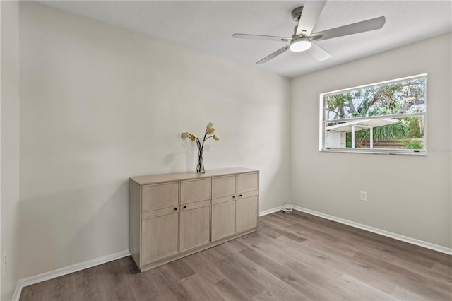 interior space with ceiling fan, a textured ceiling, and light wood-type flooring