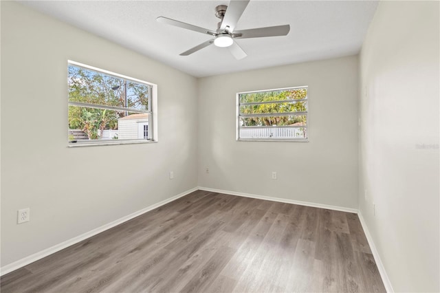 empty room with hardwood / wood-style floors and ceiling fan