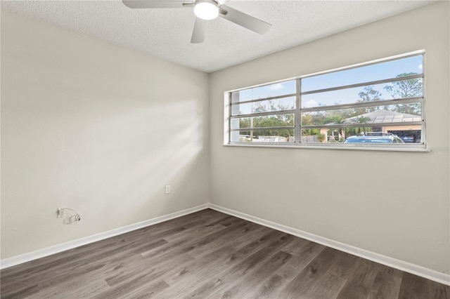 empty room with a textured ceiling, dark hardwood / wood-style floors, and ceiling fan