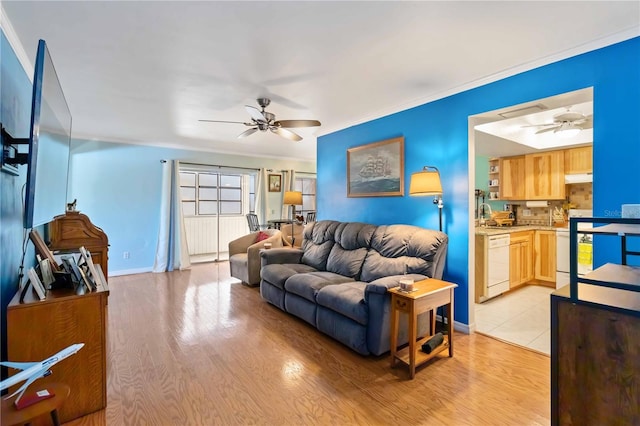 living room featuring ceiling fan, light hardwood / wood-style floors, and crown molding