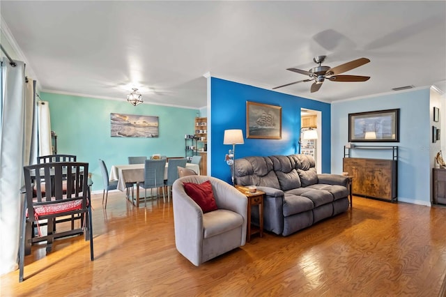 living room with ceiling fan, wood-type flooring, and ornamental molding