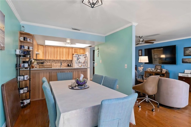 dining area with dark hardwood / wood-style floors, ceiling fan, and ornamental molding