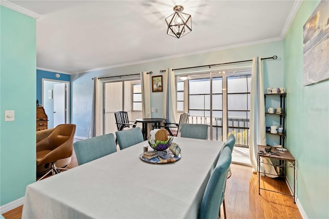 dining room featuring light hardwood / wood-style flooring and crown molding