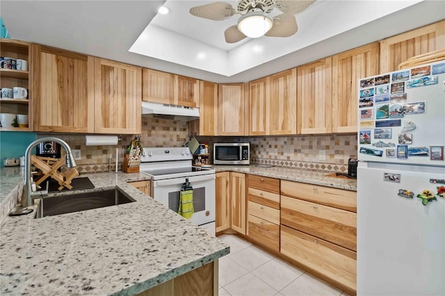 kitchen featuring light brown cabinetry, ceiling fan, sink, and white appliances