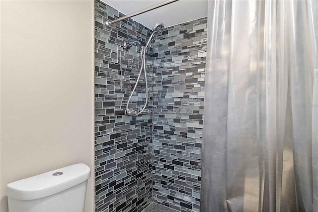 bathroom featuring toilet and curtained shower