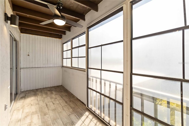 unfurnished sunroom with beamed ceiling and ceiling fan