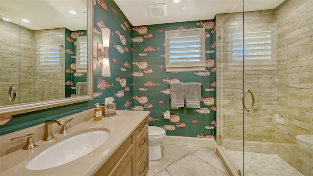 bathroom featuring a tile shower, tile patterned floors, vanity, and toilet