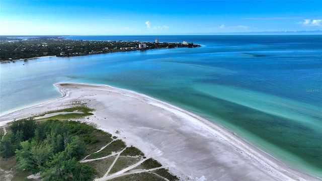 birds eye view of property with a water view and a beach view