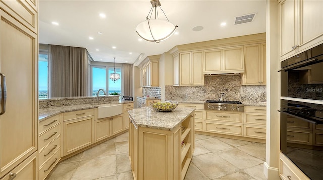 kitchen with kitchen peninsula, sink, a kitchen island, and hanging light fixtures