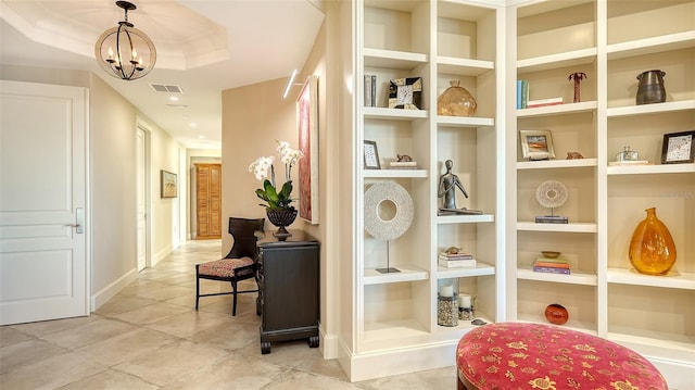 interior space with a tray ceiling and an inviting chandelier