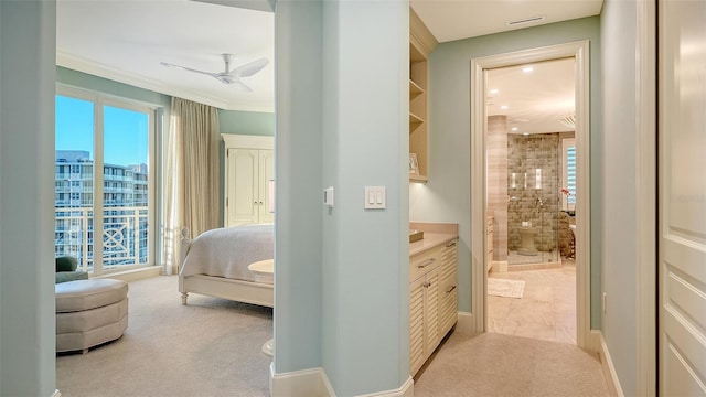 carpeted bedroom featuring ensuite bathroom, ceiling fan, and ornamental molding