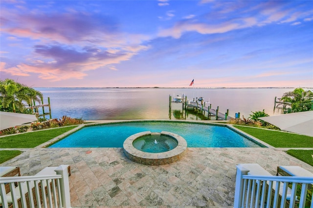 pool at dusk featuring a boat dock, a water view, and an in ground hot tub