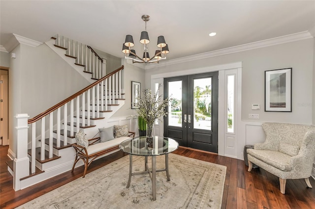 foyer with a chandelier, hardwood / wood-style floors, french doors, and ornamental molding