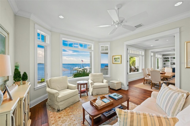 sunroom featuring ceiling fan and a water view