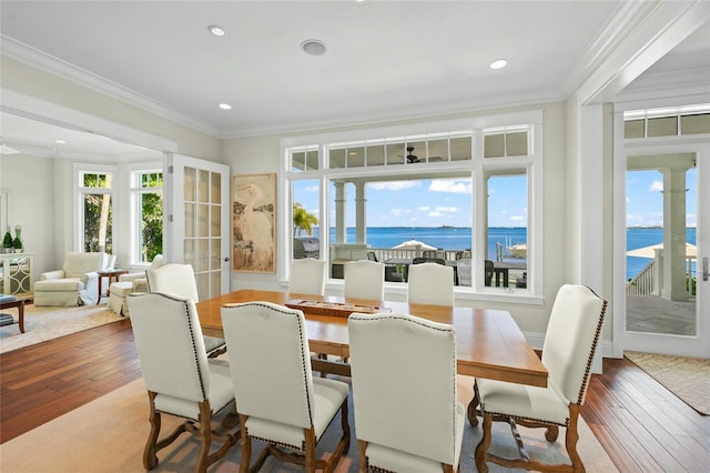 sunroom / solarium featuring french doors and a water view