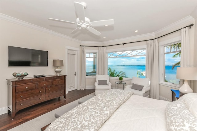 bedroom featuring multiple windows, a water view, ceiling fan, and dark hardwood / wood-style floors