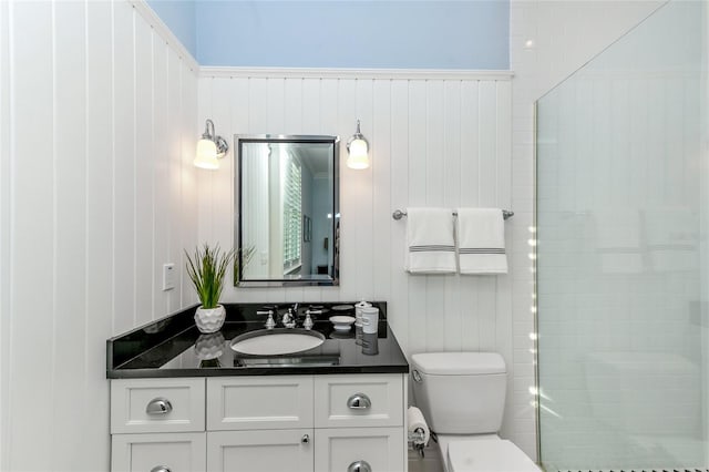 bathroom featuring vanity, toilet, and wood walls