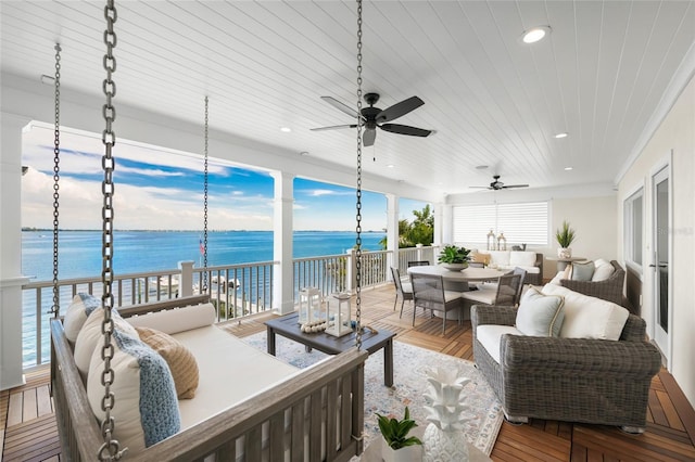 sunroom with ceiling fan, a water view, and wood ceiling